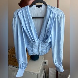 Fashion Nova long sleeve baby blue top. Runch details and clasps to connect.